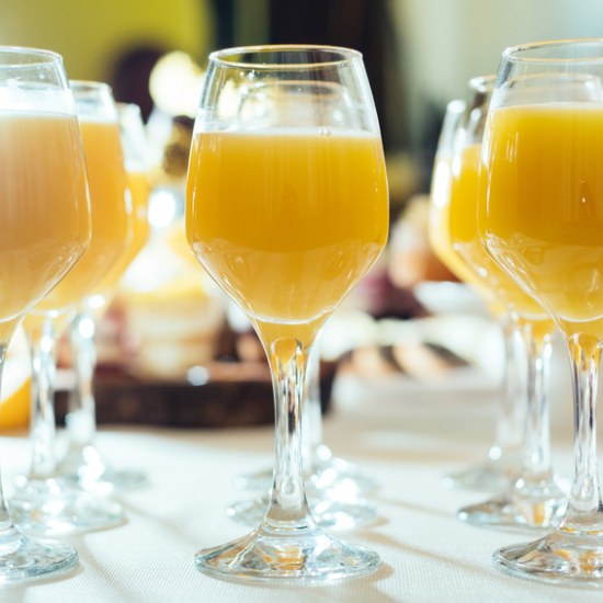 Glasses with tasty fresh orange fruit juice on summer wedding greeting